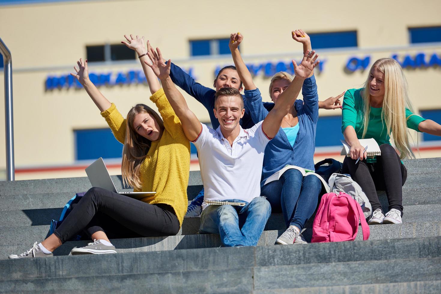 Studenten sitzen draußen auf Stufen foto