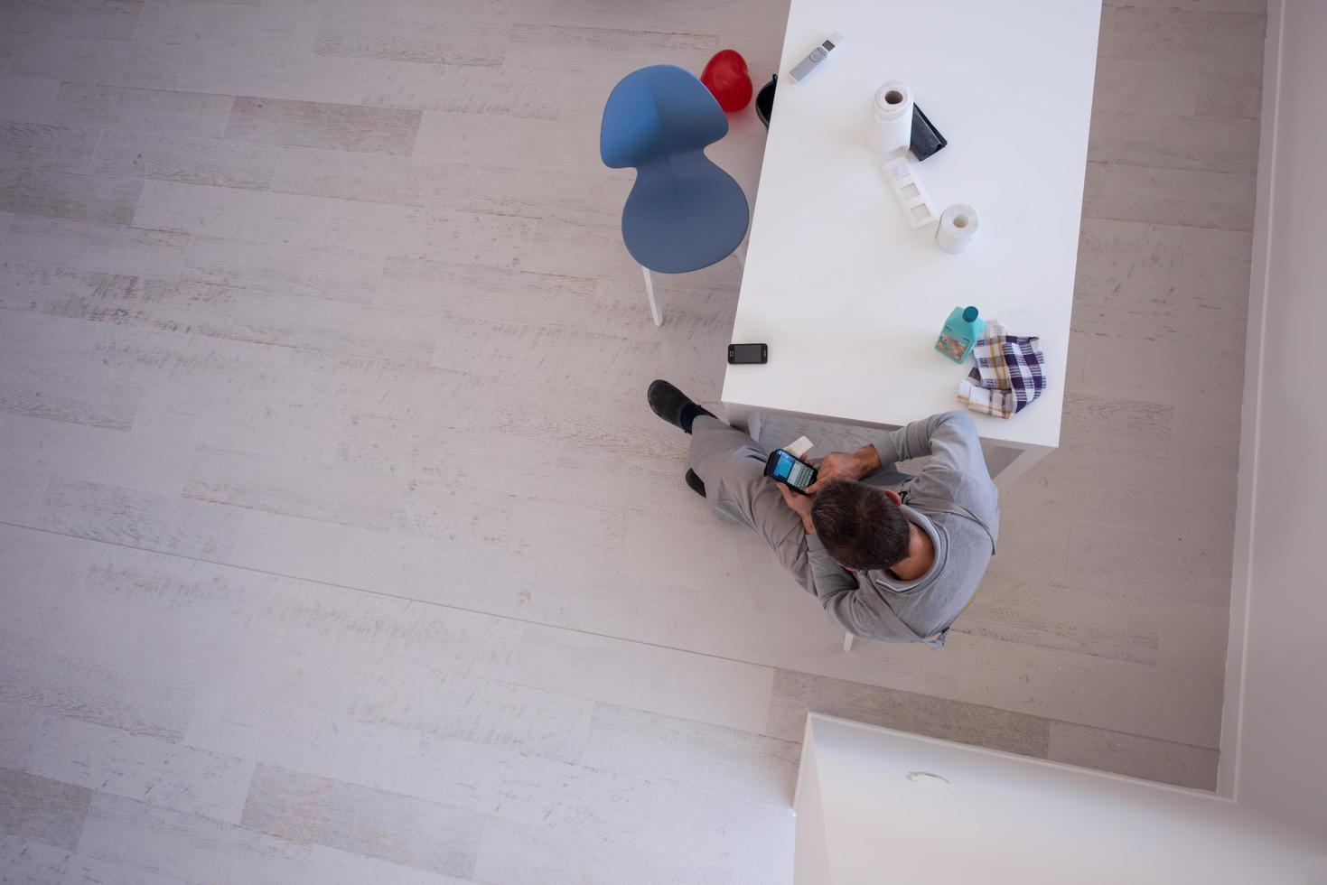 Draufsicht des jungen Malers im Arbeitsanzug mit Handy foto