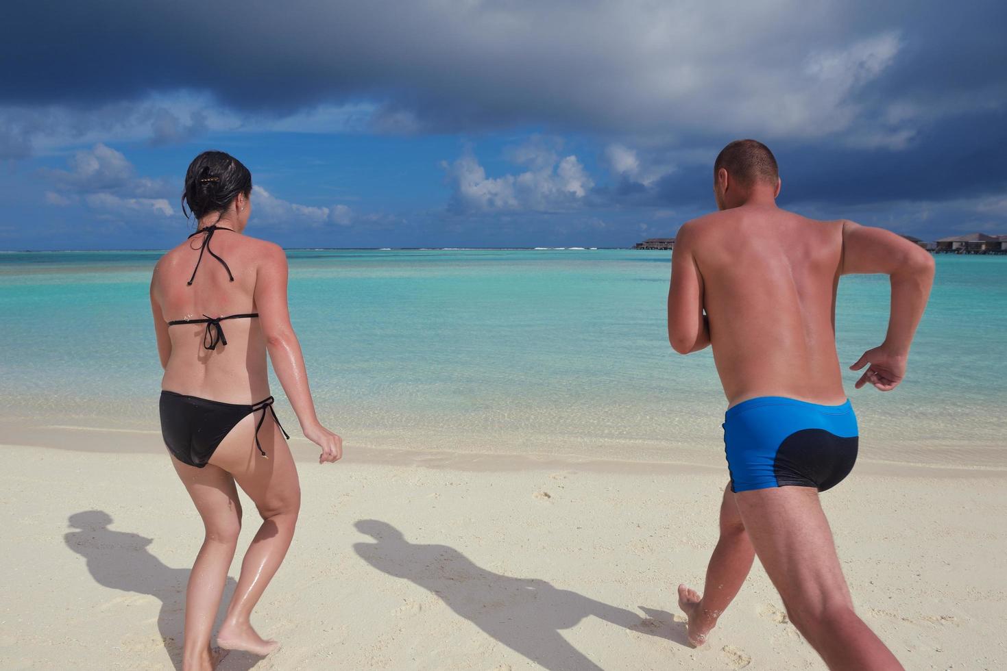 glückliches junges Paar in den Sommerferien hat Spaß und entspannt sich am Strand foto