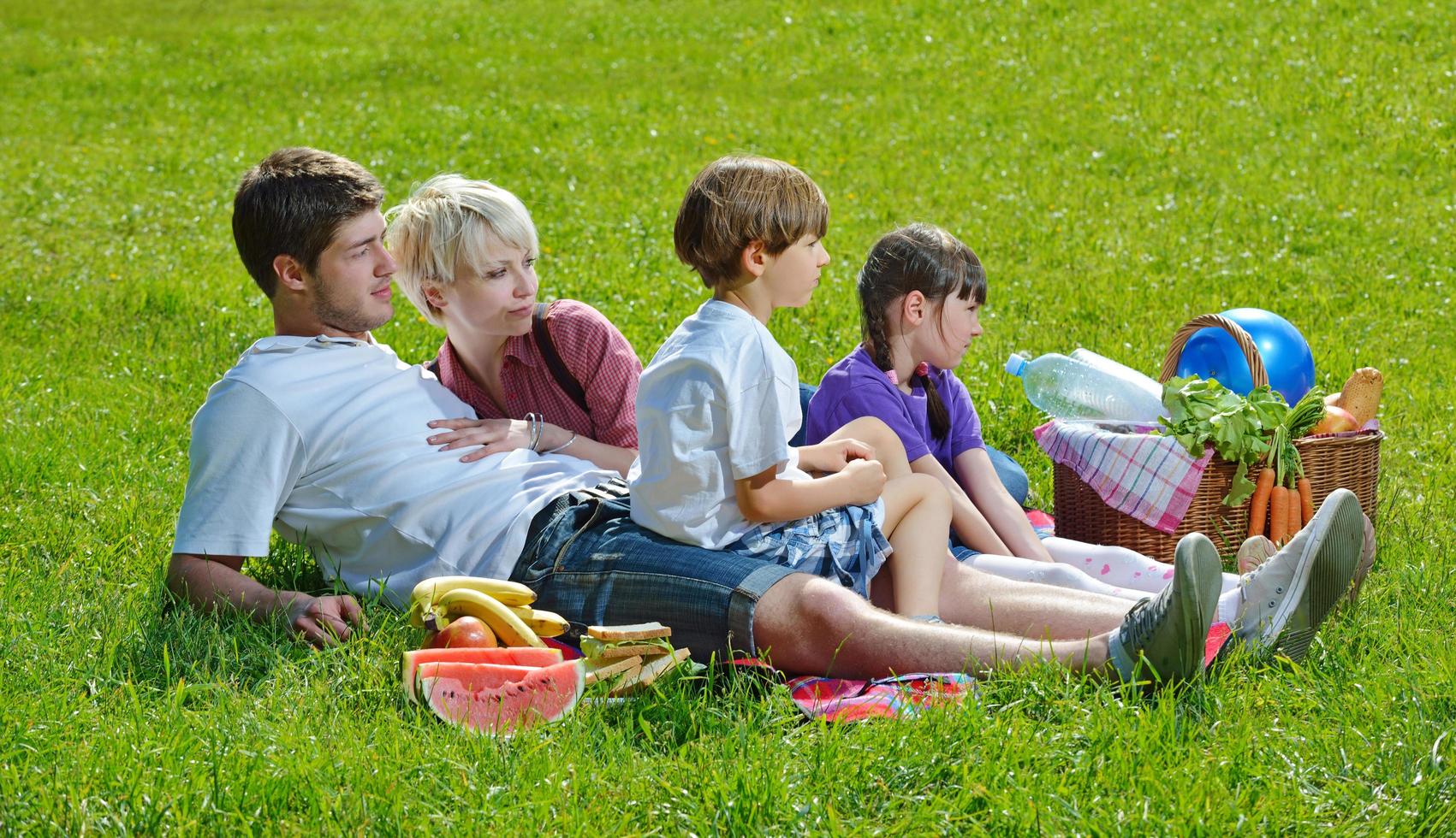 glückliche familie, die zusammen in einem picknick im freien spielt foto