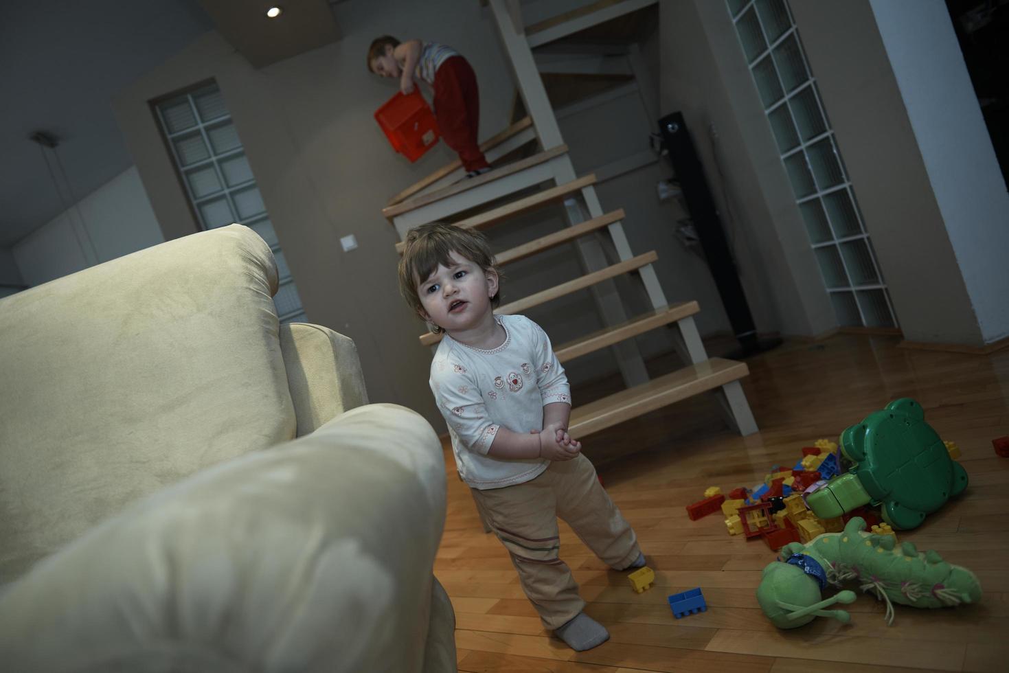 entzückendes, süßes, schönes kleines Mädchen, das zu Hause mit Spielzeug spielt foto