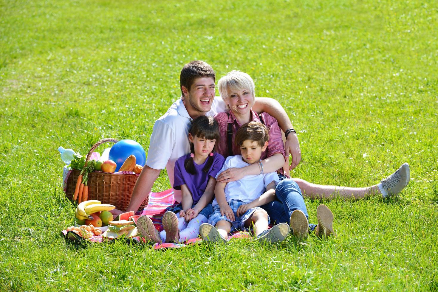 glückliche familie, die zusammen in einem picknick im freien spielt foto