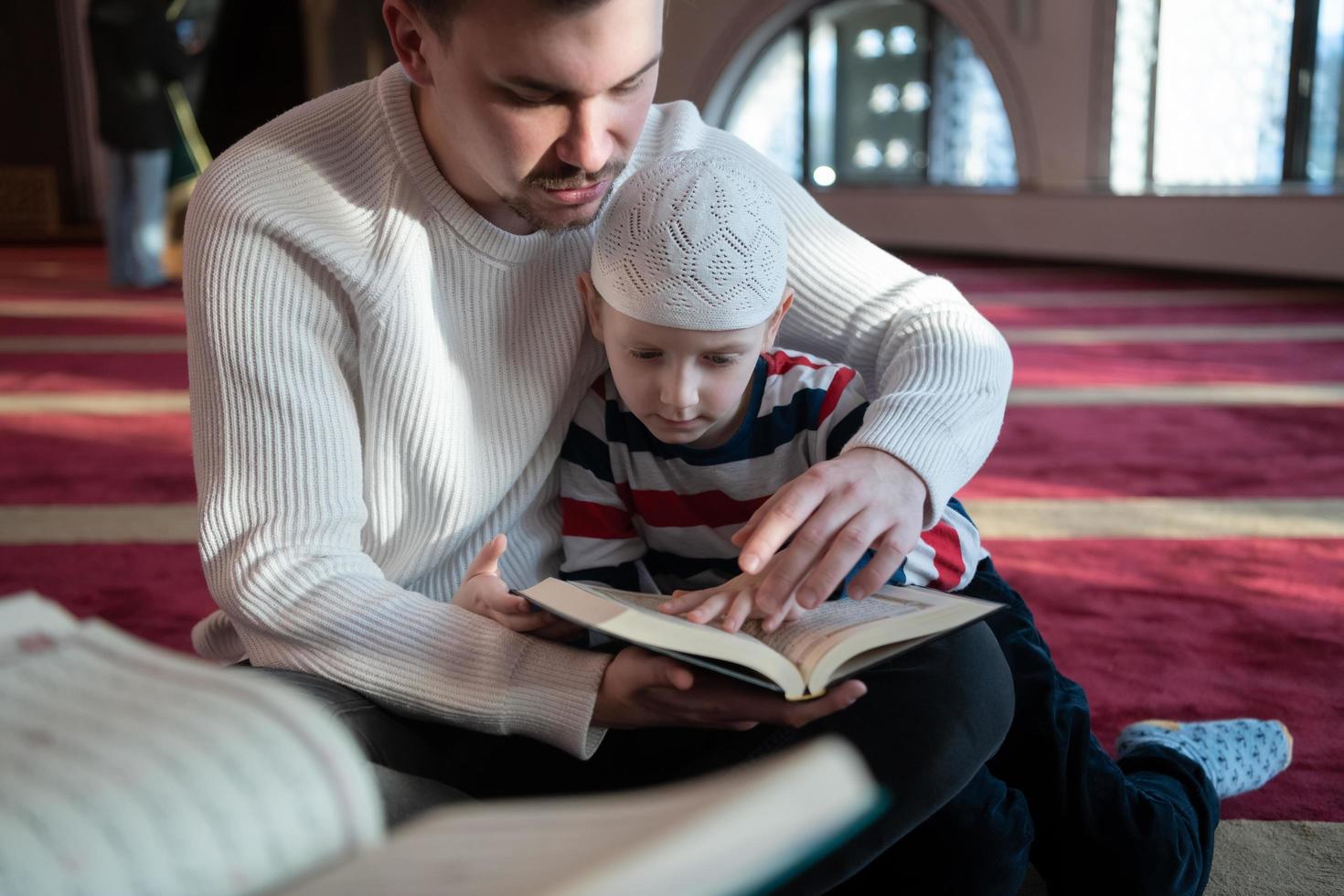 muslimischer gebetsvater und sohn in der moschee beten und lesen holly book quran zusammen islamisches bildungskonzept foto