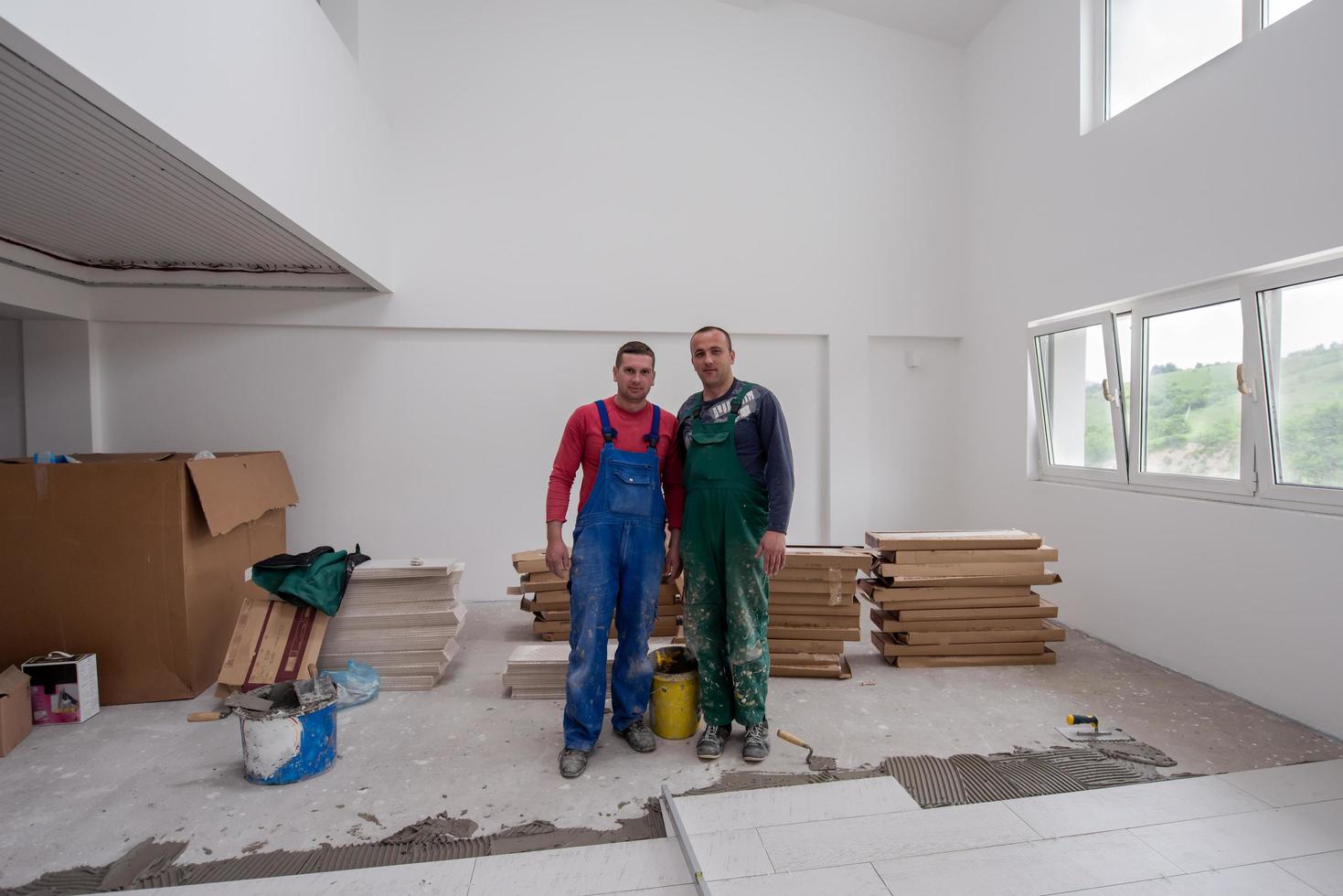 Porträt von Arbeitern und Bauarbeitern mit schmutziger Uniform in der Wohnung foto