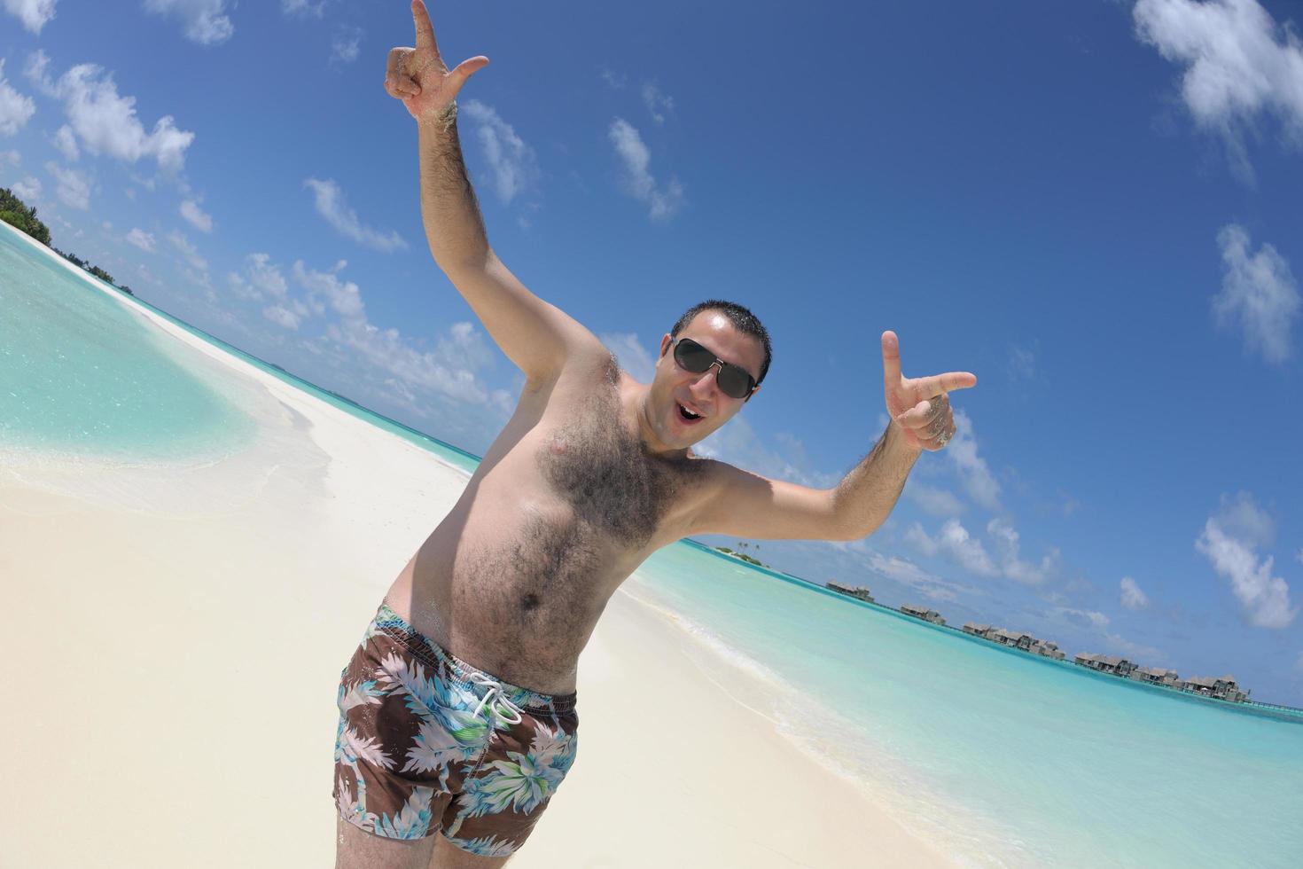 junger mann hat spaß und entspannt sich am strand foto