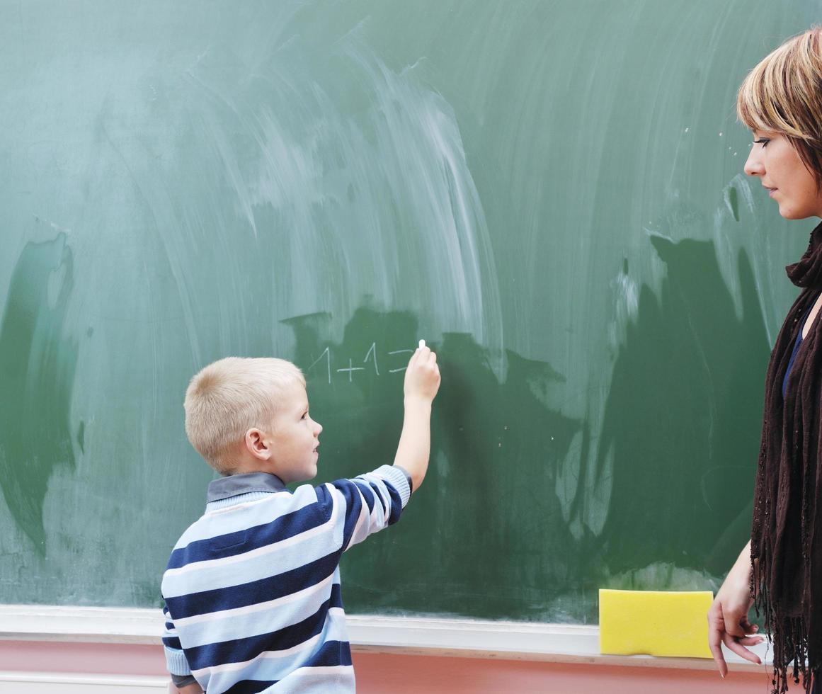 glücklicher kleiner junge im matheunterricht der ersten klasse foto