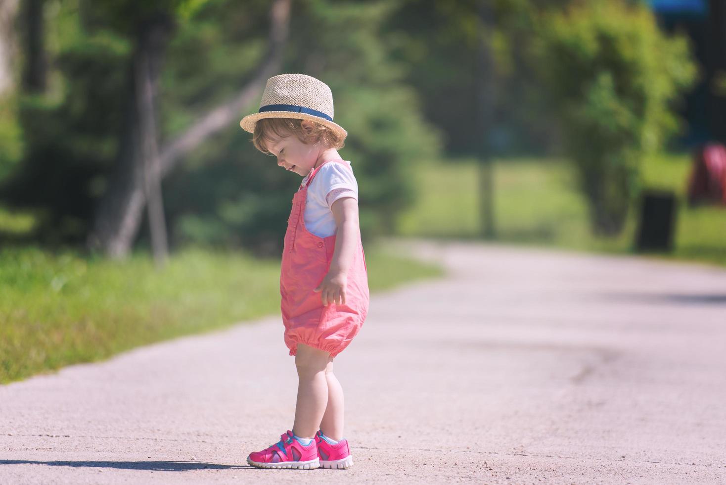 kleines Mädchen, das im Sommerpark läuft foto