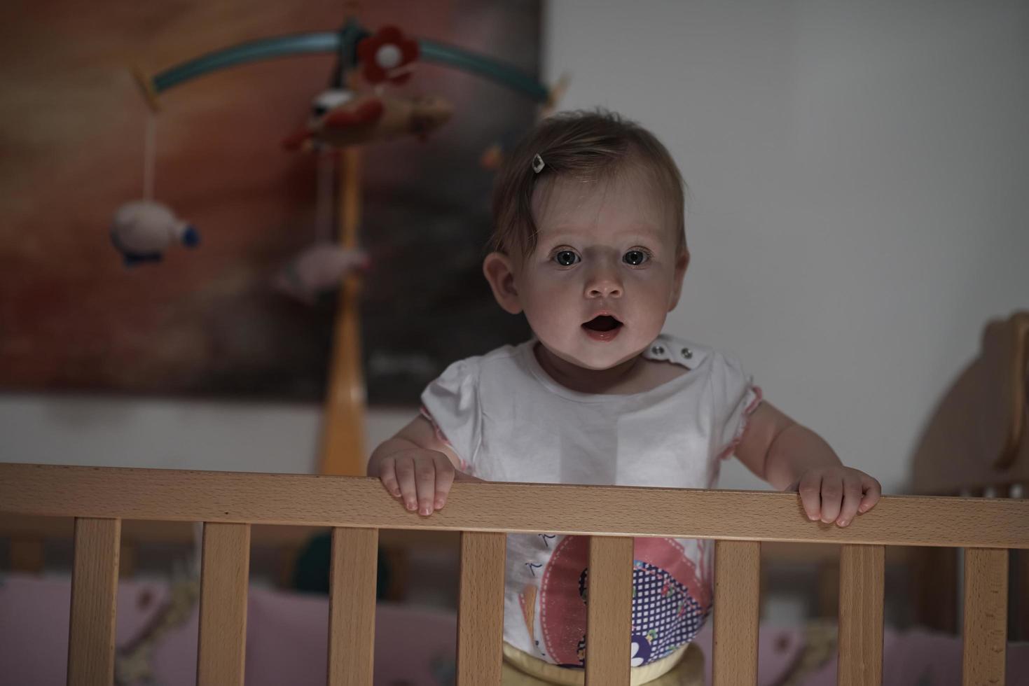 süßes kleines einjähriges baby und macht erste schritte im bett foto