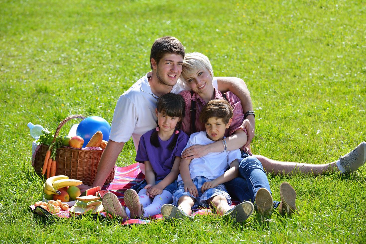 glückliche familie, die zusammen in einem picknick im freien spielt foto