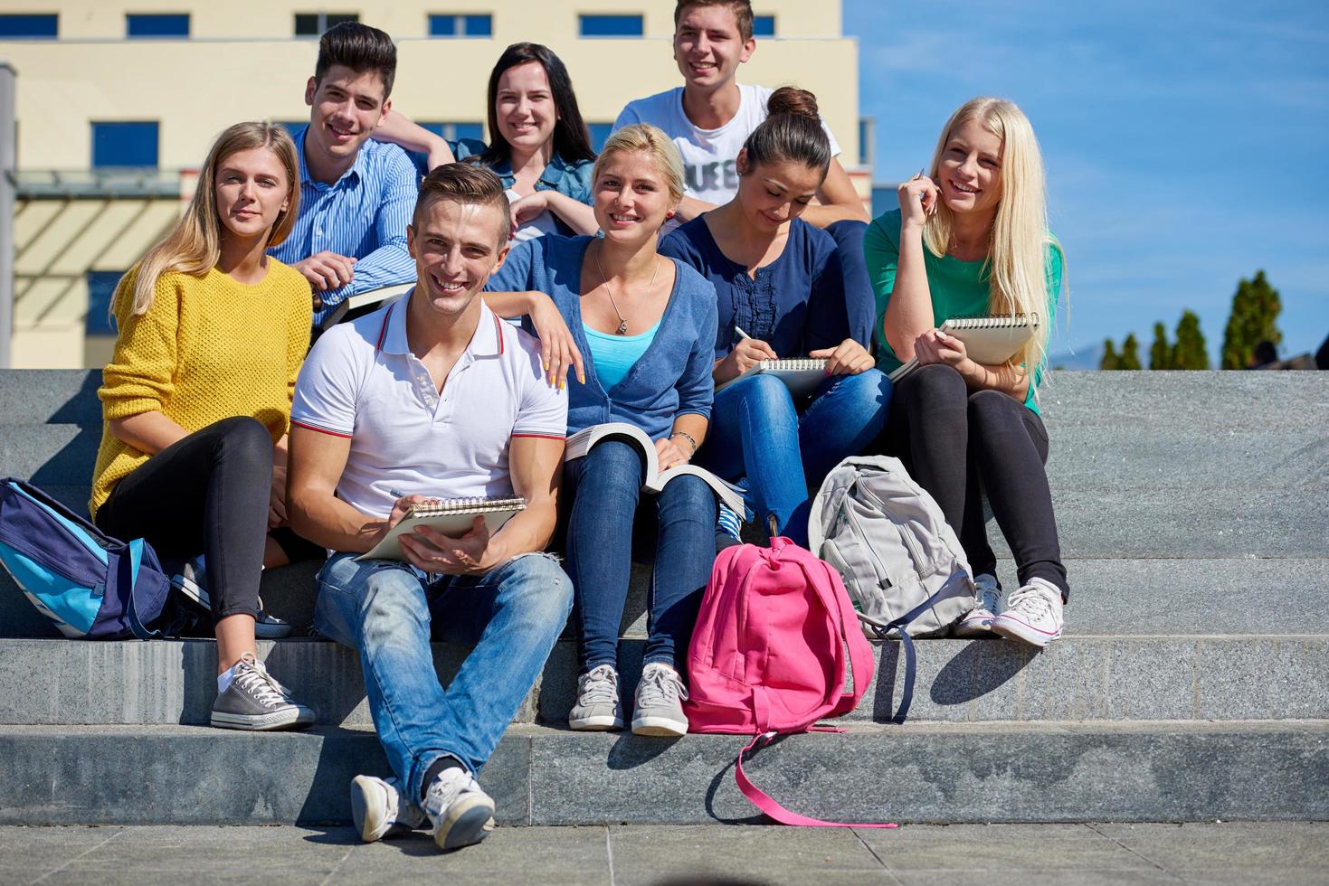 Studenten sitzen draußen auf Stufen foto