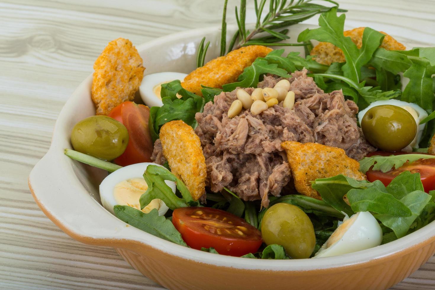 Thunfischsalat in einer Schüssel auf Holzhintergrund foto