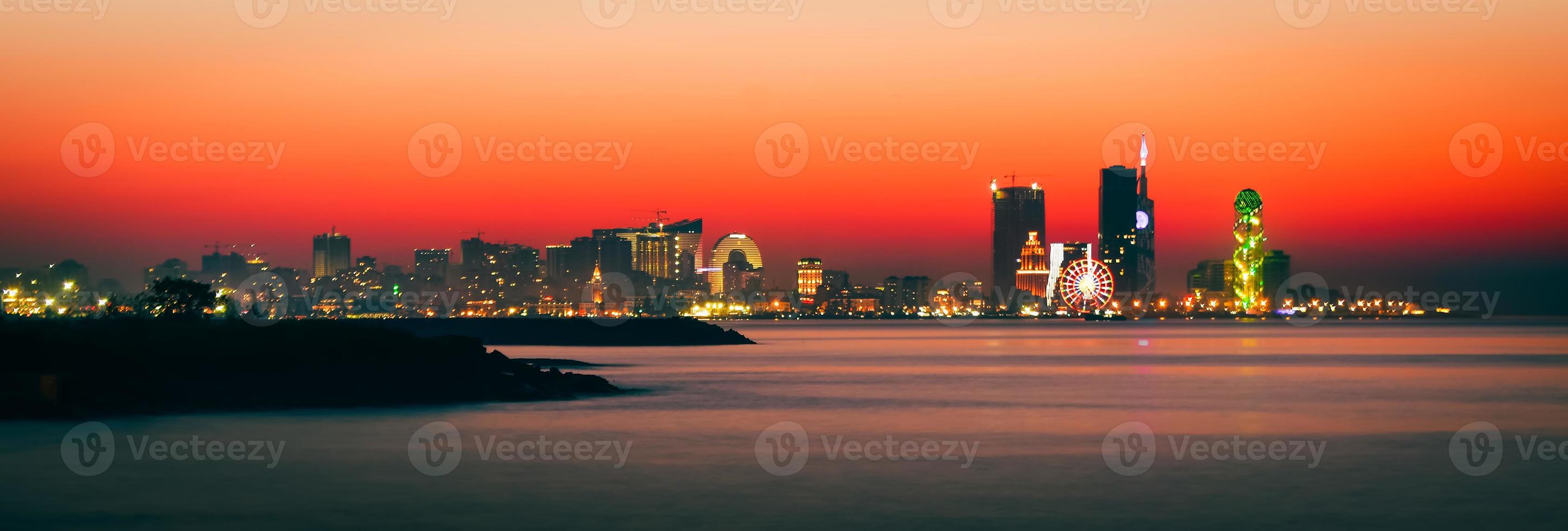 Atemberaubende schöne Ufergegend von Batumi in Adjara, Georgia. Moderne Architektur an der Strandpromenade in Nacht- oder Abendbeleuchtung, beleuchtete Wolkenkratzer im Stadtbild der Ferienorte foto