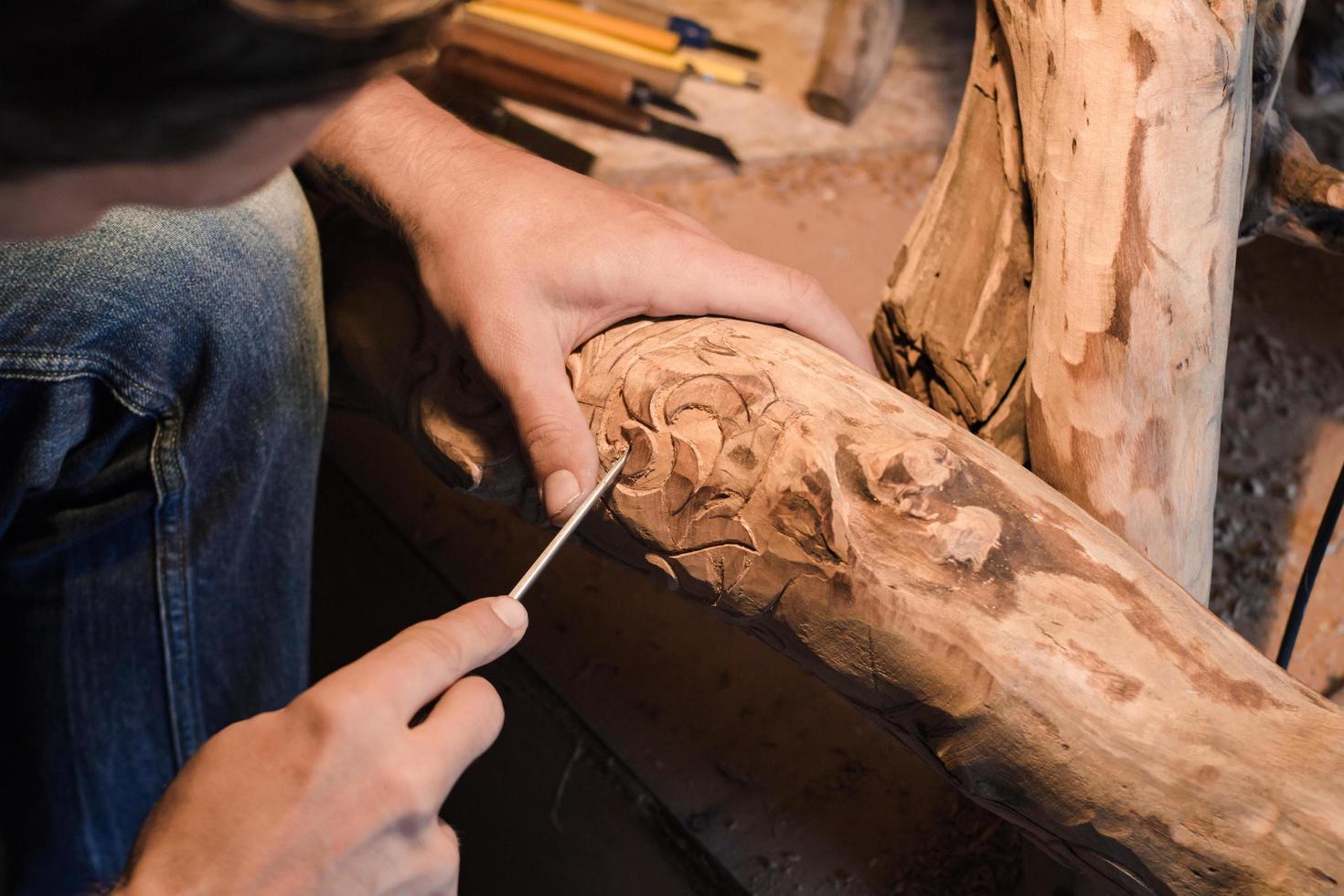 nahaufnahmebild des holzschnitzers bei der arbeit, handarbeit mit holz foto