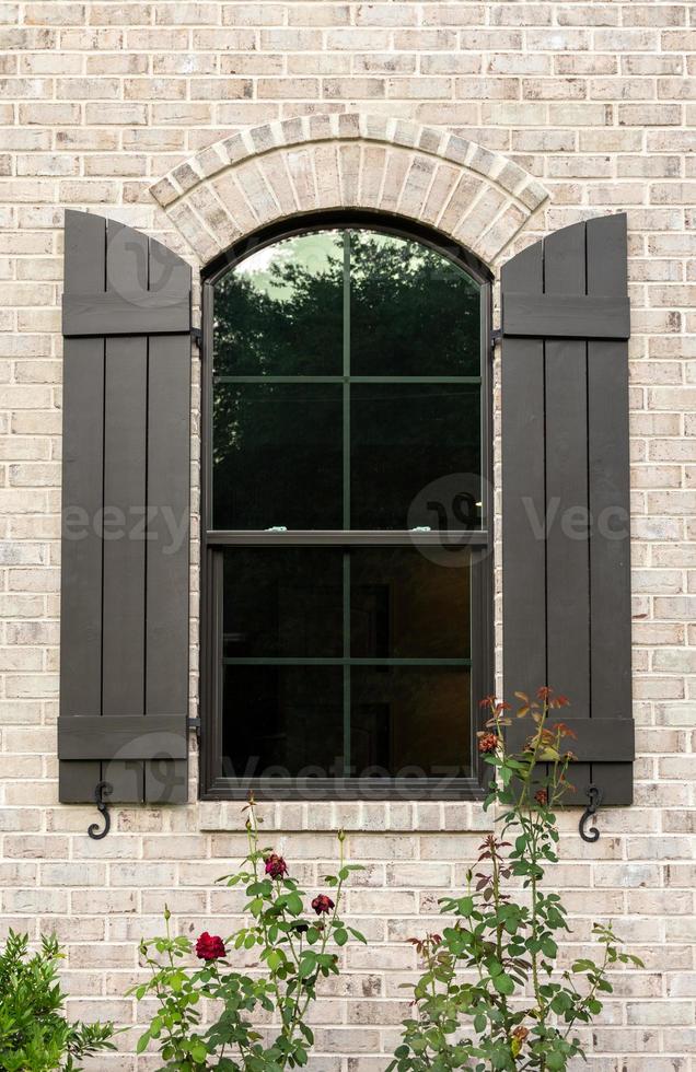 gehobenes ziegelsteinhausfenster mit rosen foto