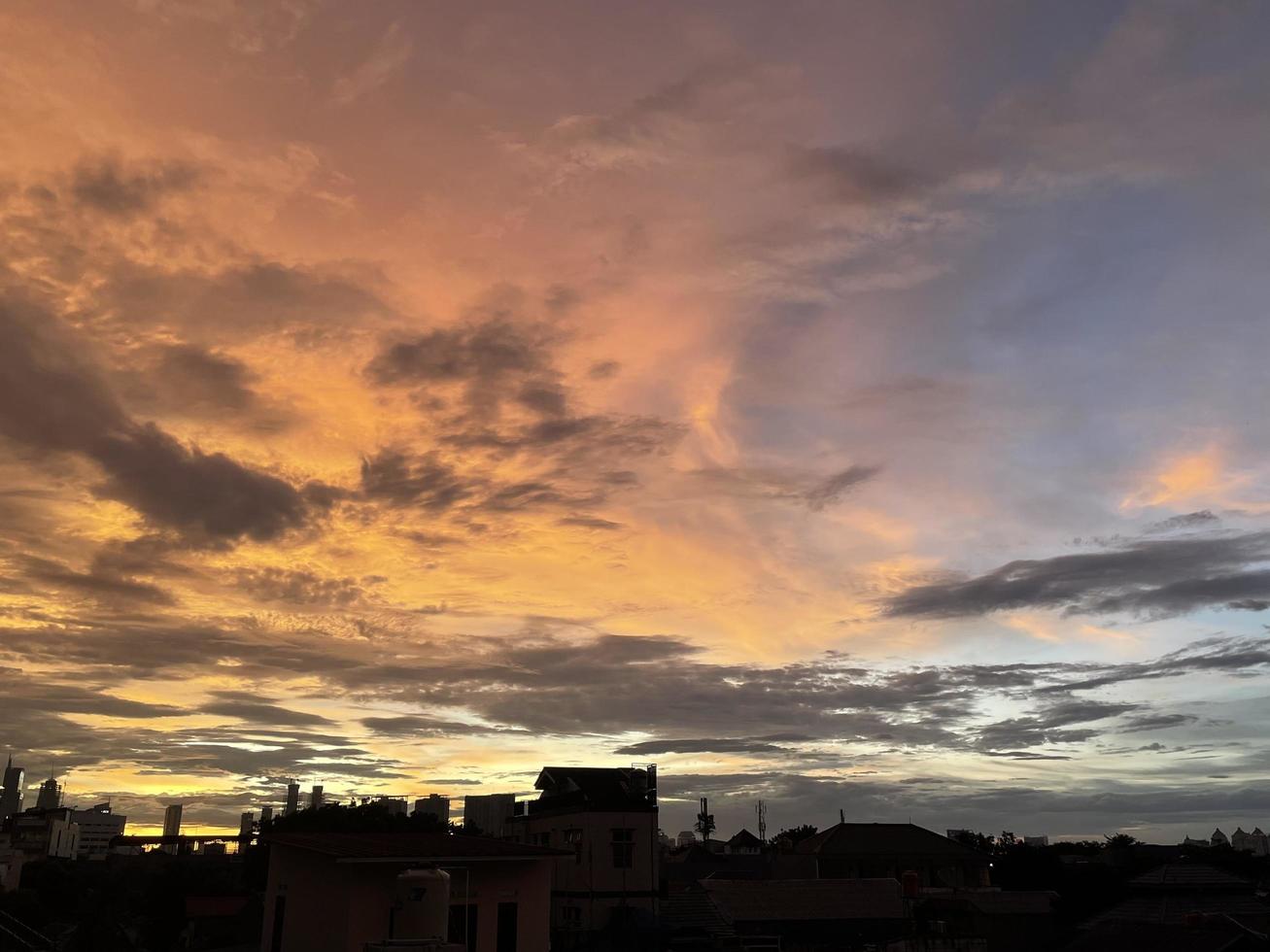 Sehr schöner Dämmerungshimmel, eine Mischung aus orangen und blauen Farben. schöner Blick in den Abendhimmel. Wolken, Himmel und Regenbogen, die am Nachmittag die Atmosphäre schmücken. Abendansicht in Jakarta. verwischen foto