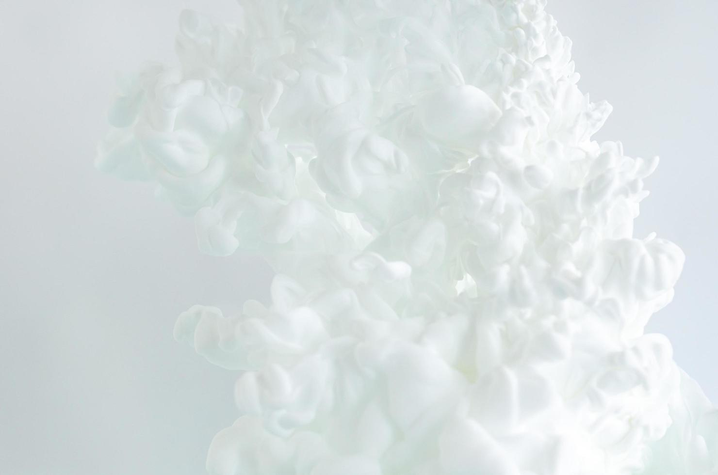 verschwommene und fokussierte weiße Plakatfarbe, die sich in Wasser auflöst für abstraktes und Hintergrundkonzept. foto