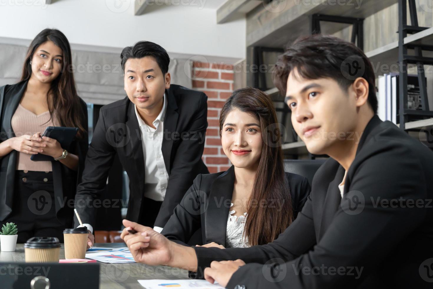 glückliche gruppe von geschäftsleuten während der präsentation. geschäftsleute, die als team im büro arbeiten foto