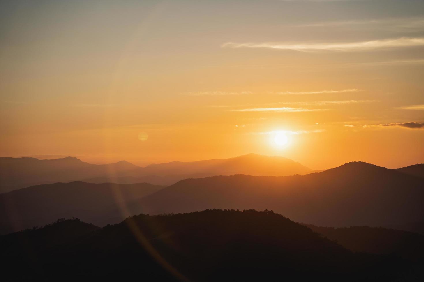 Sonnenuntergangslandschaft mit Berg- und Sonnengoldbeleuchtung unter lebendigem, farbenfrohem Abendhimmel in den Bergen. natur berg himmel und wolken sonnenuntergang konzept foto