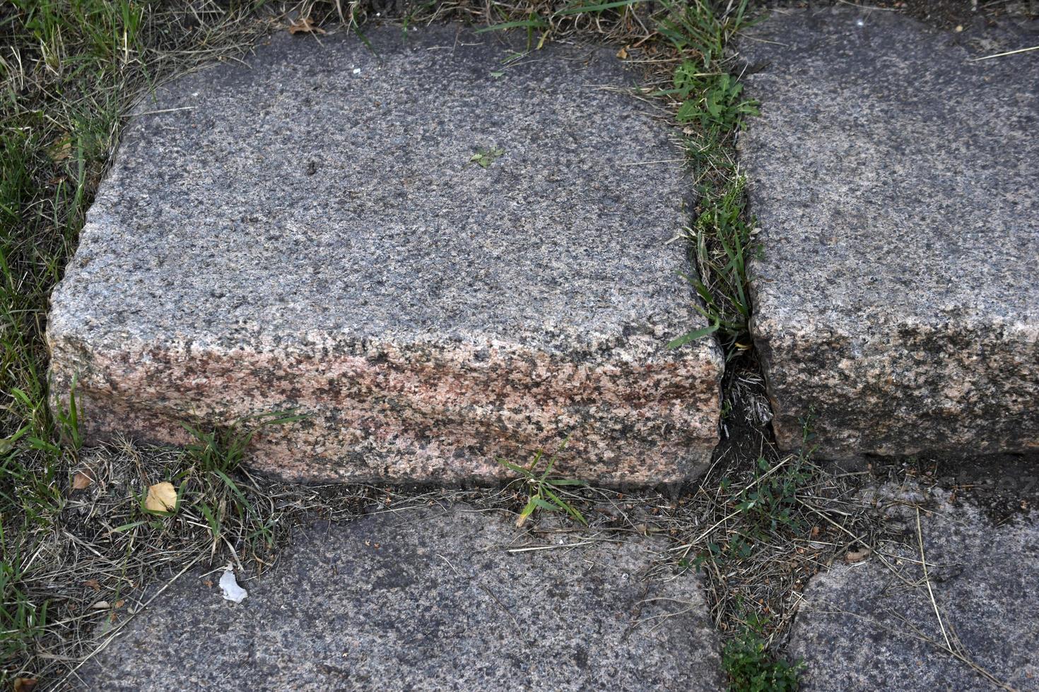 ein Steinweg im Park und eine Granittreppe mit Stufen. Steinstufen im Garten. foto