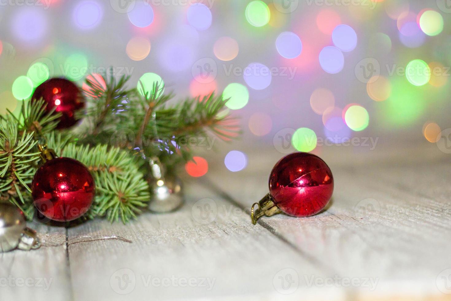 Weihnachtsfeiertagshintergrund. Silberne und rote Kugel, die an einem geschmückten Baum mit Bokeh hängt, Kopierraum foto