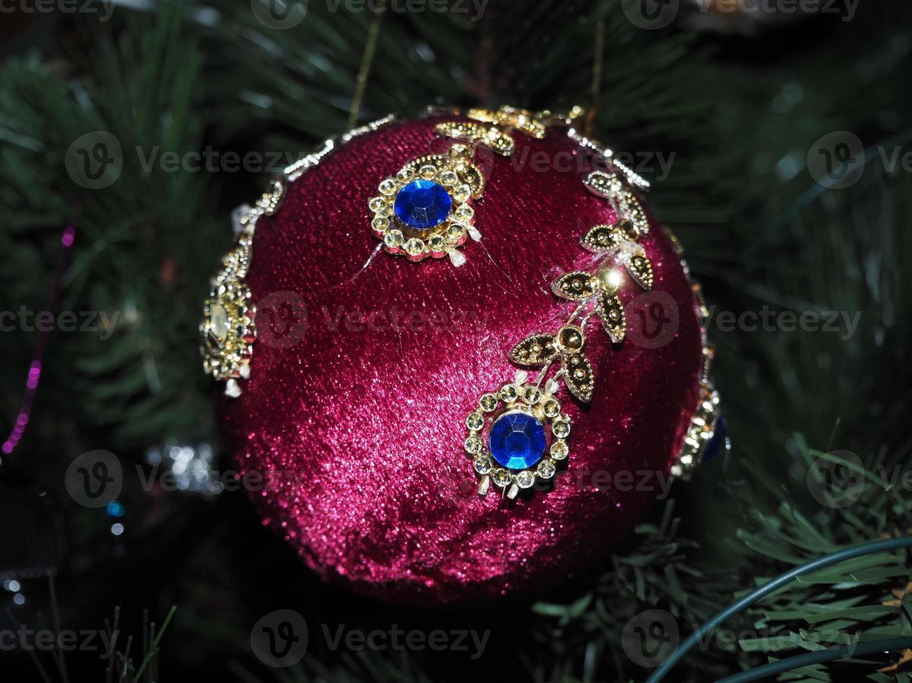 Handgemachte Weihnachtskugel aus Glas auf Weihnachtsbaum-Detailunschärfelichtern foto