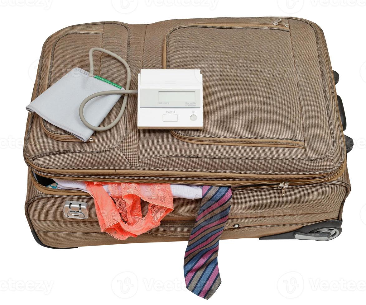 Blutdruckmessgerät auf Koffer mit Krawatte und Höschen foto