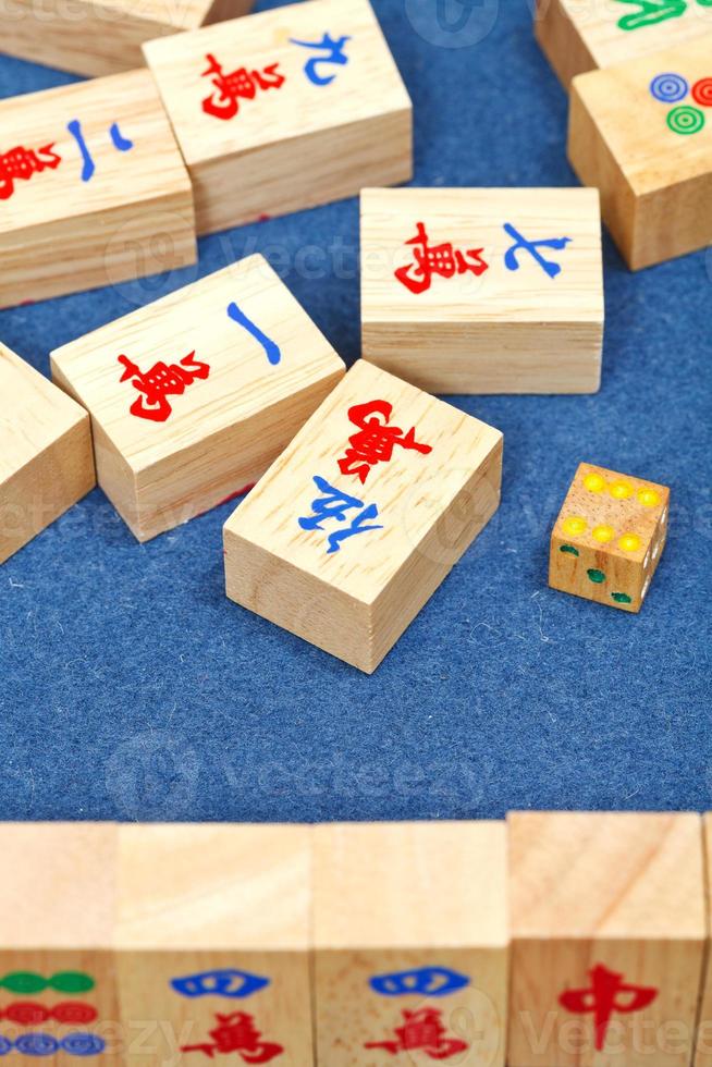 Holzfliesen im Mahjong-Spiel auf blauem Stofftisch foto
