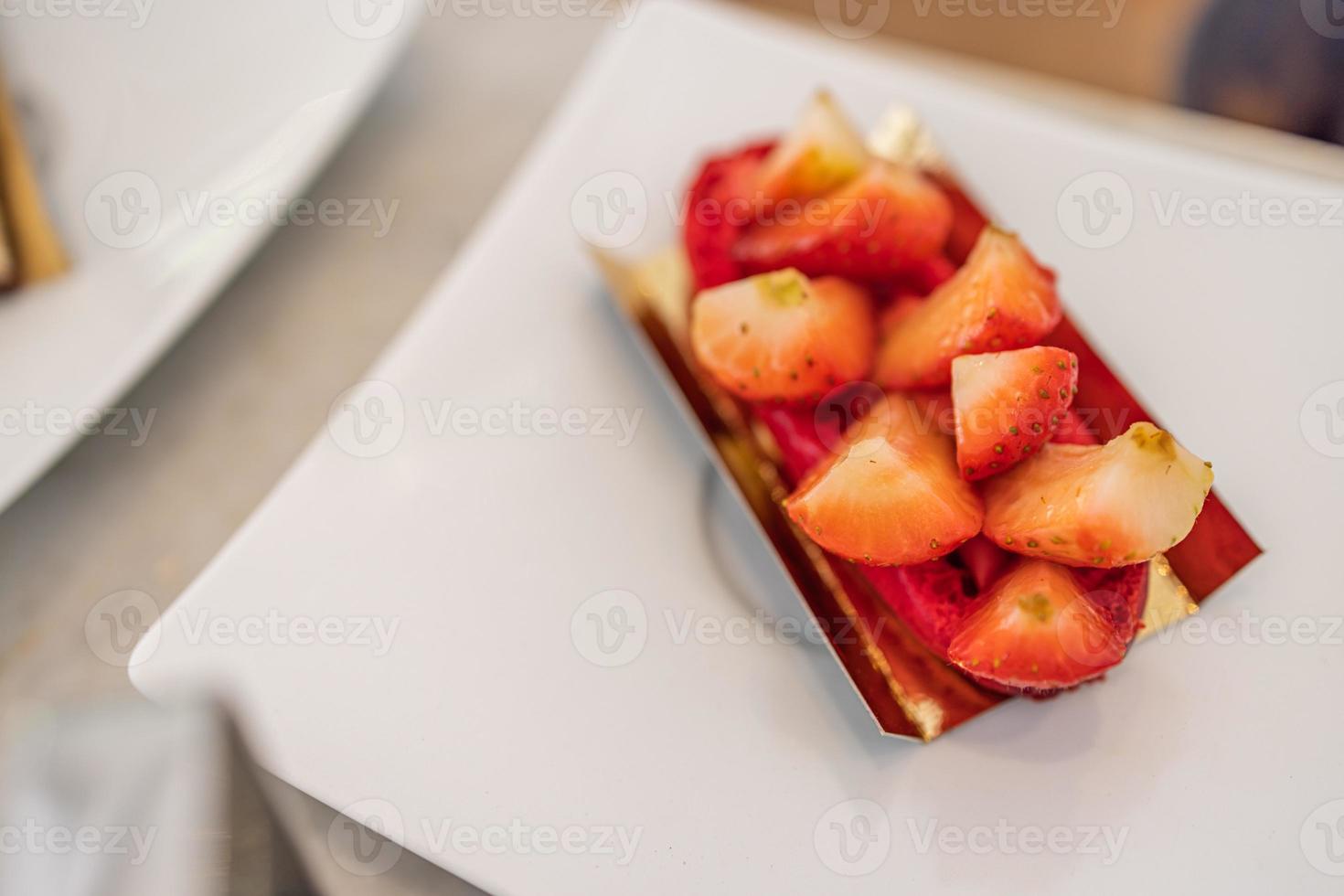 in Scheiben geschnittene Erdbeeren isoliert auf weißem Hintergrund, selektiver Fokus, Nahaufnahme im eleganten Luxusrestaurant. Erdbeerkuchen foto