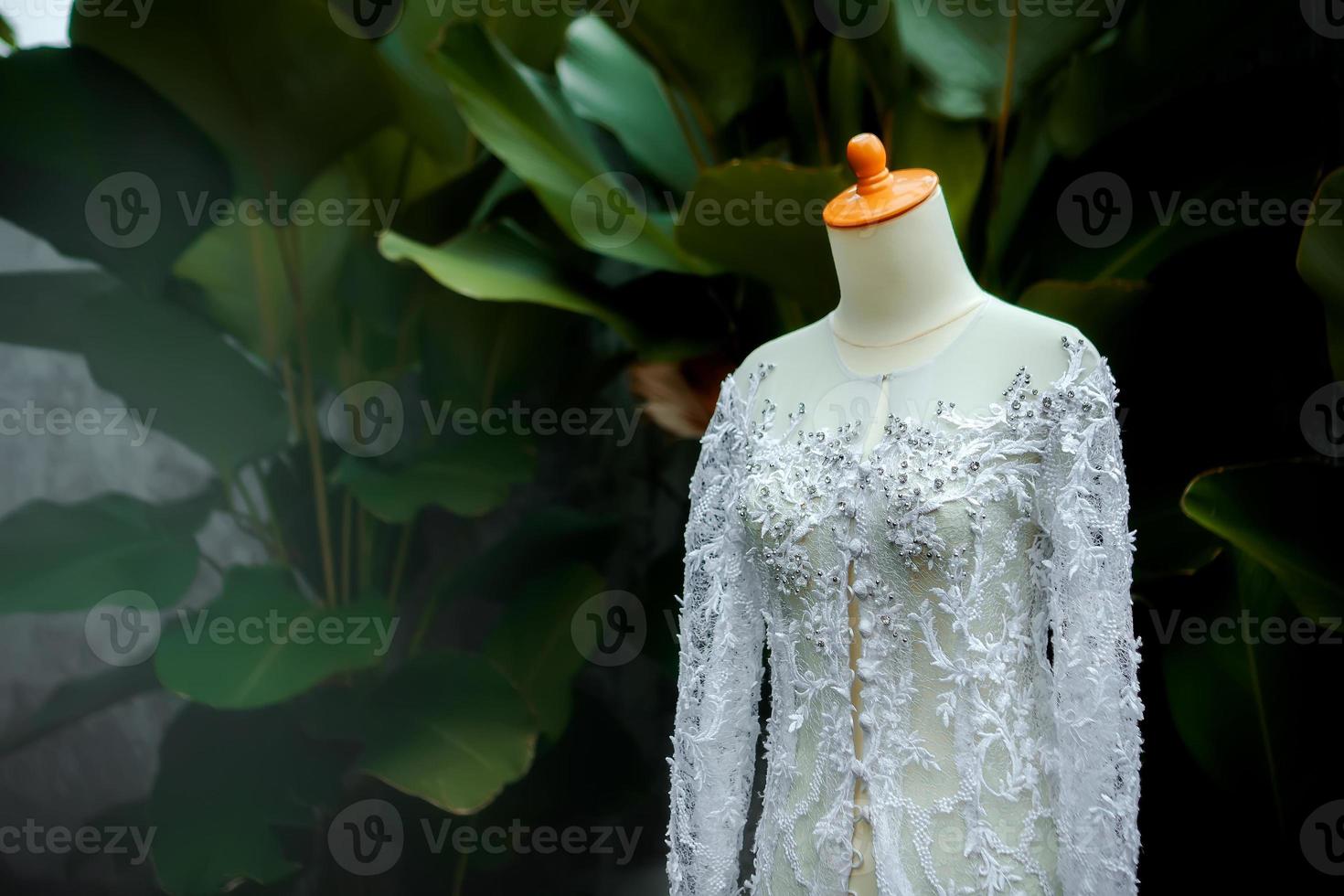 wunderschönes Hochzeitskleid. Mode sieht aus. Hochzeitskleid auf Grünpflanzenhintergrund. foto