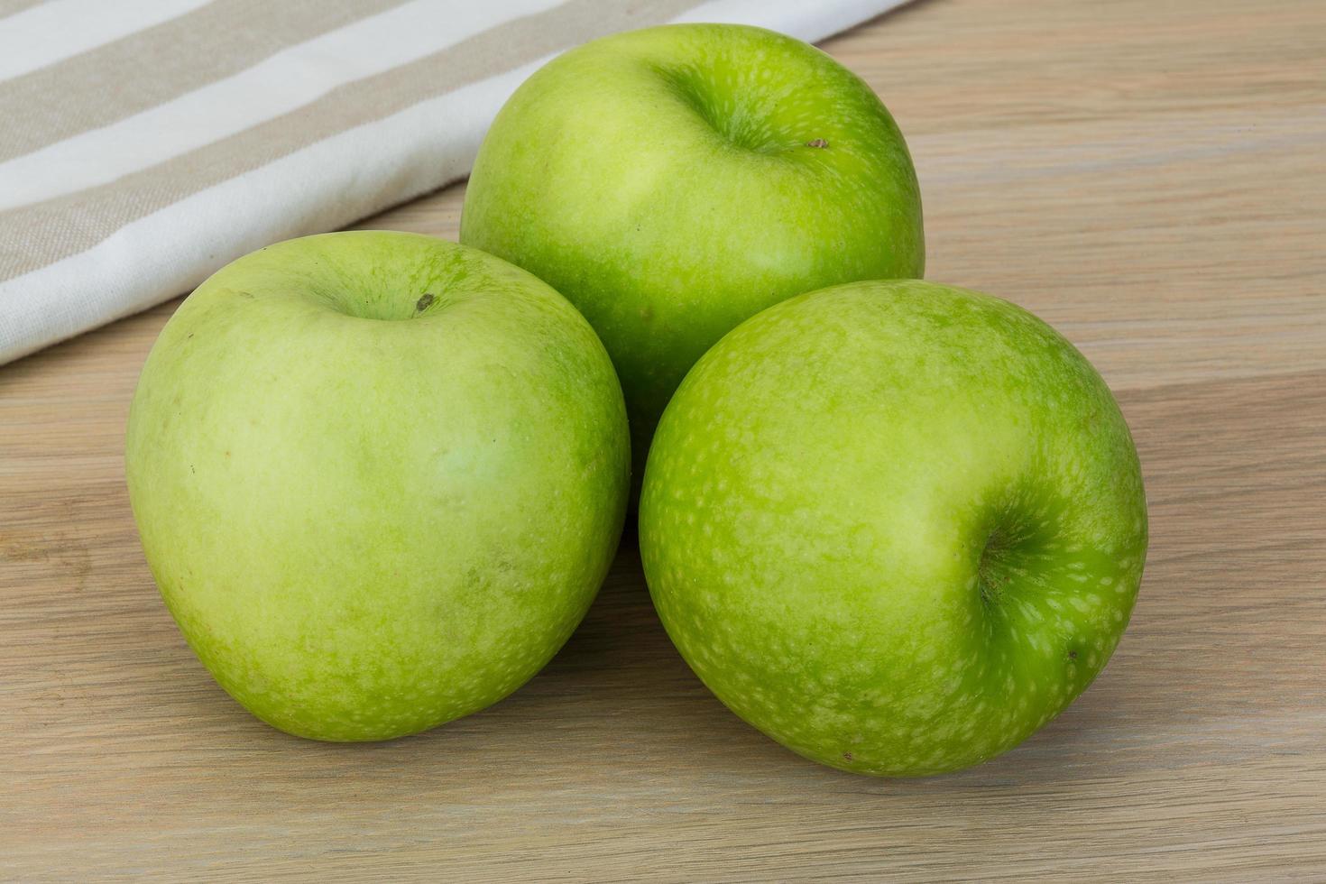 grüner Apfel auf hölzernem Hintergrund foto