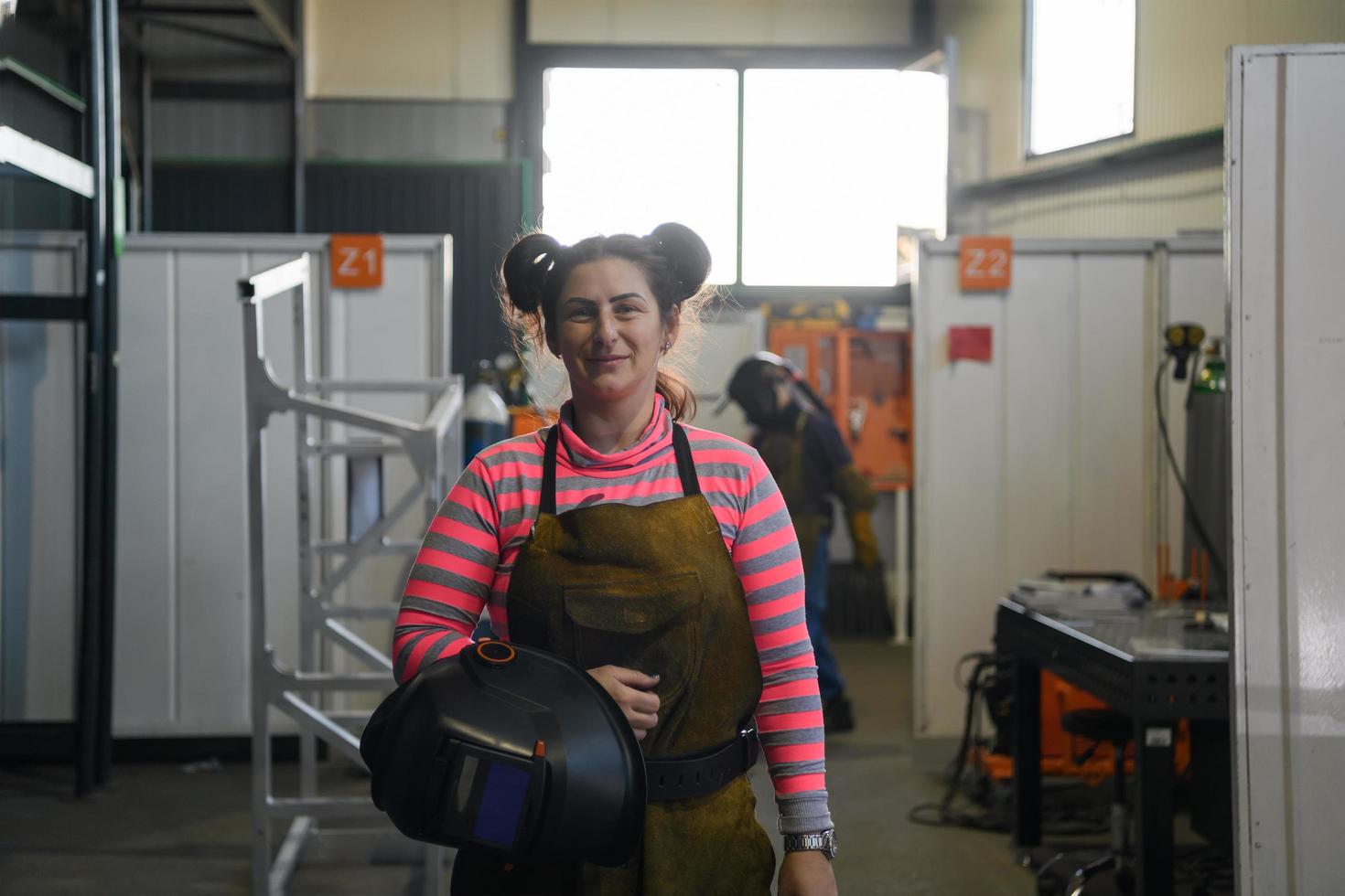 ein Porträt einer Schweißerin mit Helm, die sich auf einen Arbeitstag in der Metallindustrie vorbereitet foto