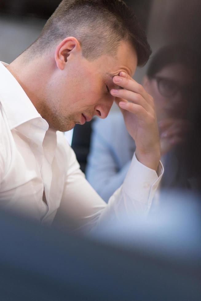 junger geschäftsmann, der am schreibtisch sich entspannt foto