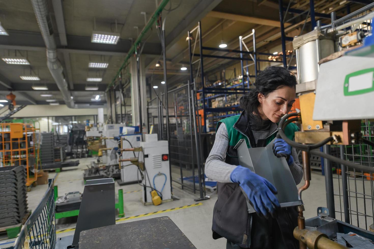 türkei, 2022 - eine frau, die in einer modernen metallfabrik arbeitet, montiert teile für eine neue maschine foto