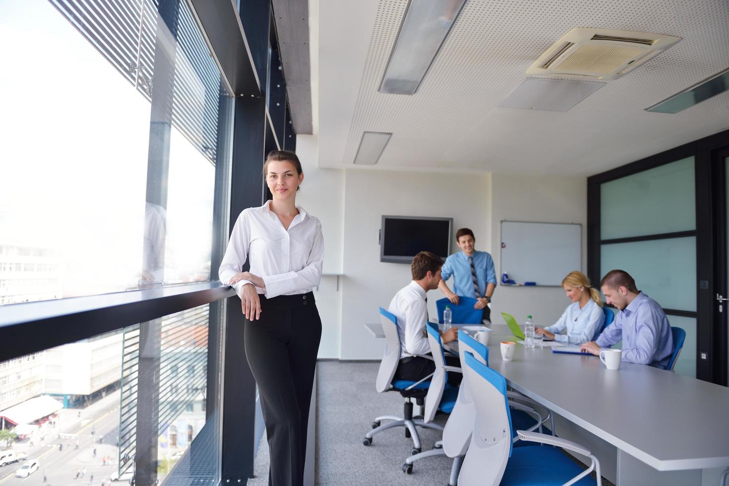 Geschäftsfrau mit ihren Mitarbeitern im Hintergrund im Büro foto