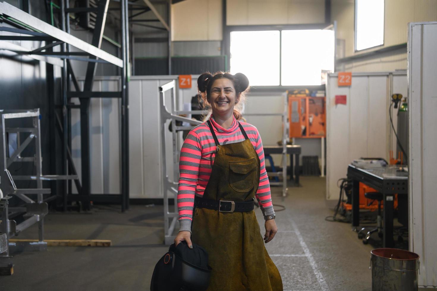 ein Porträt einer Schweißerin mit Helm, die sich auf einen Arbeitstag in der Metallindustrie vorbereitet foto