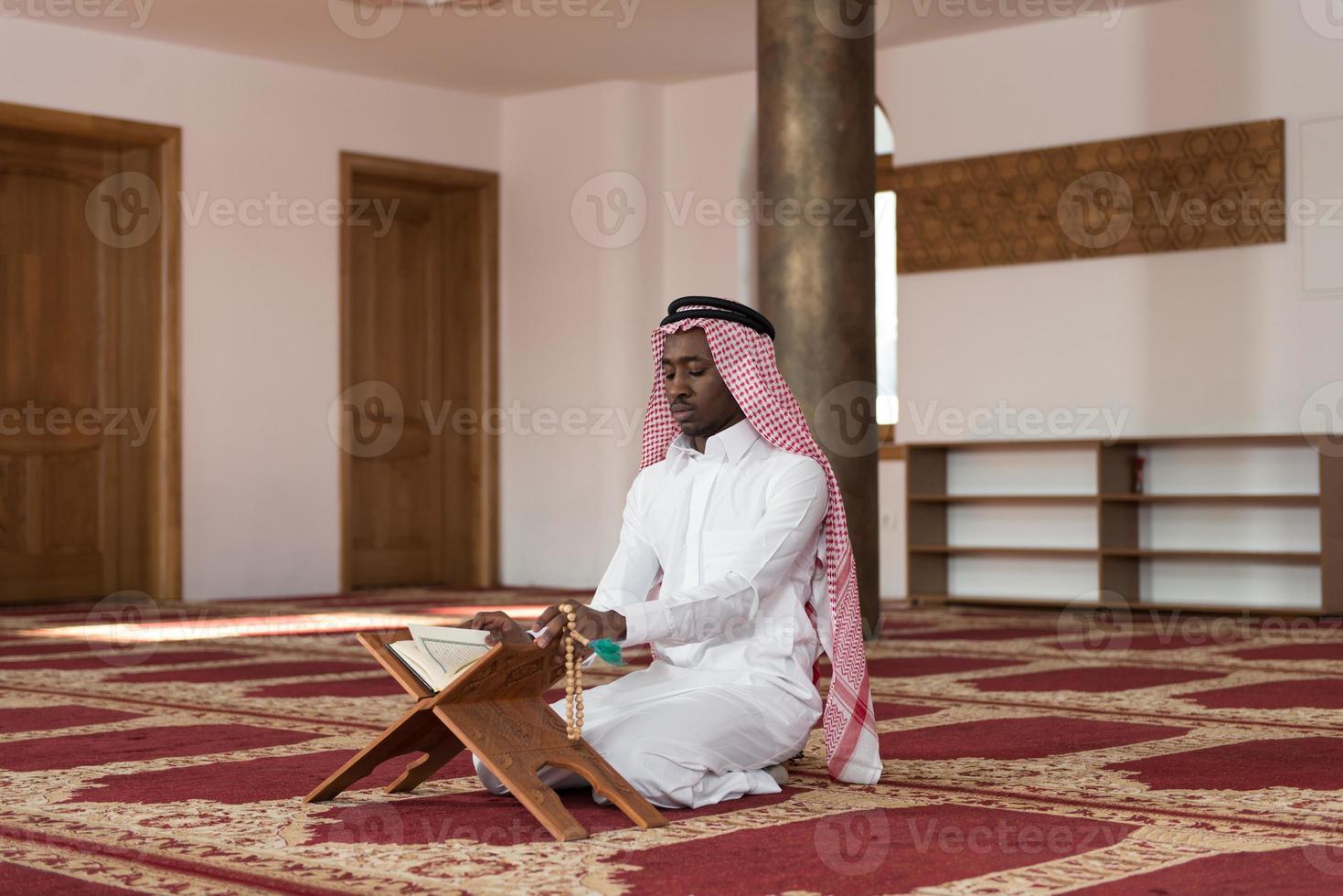 schwarzer Geschäftsmann, der den Koran liest foto