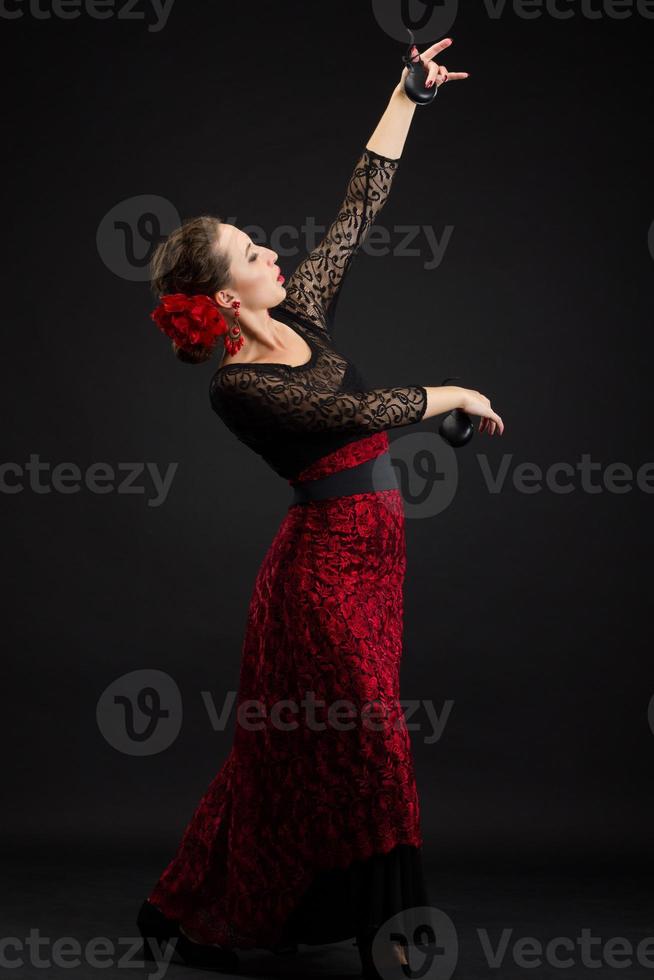 Spanische Frau tanzt Flamenco auf Schwarz foto