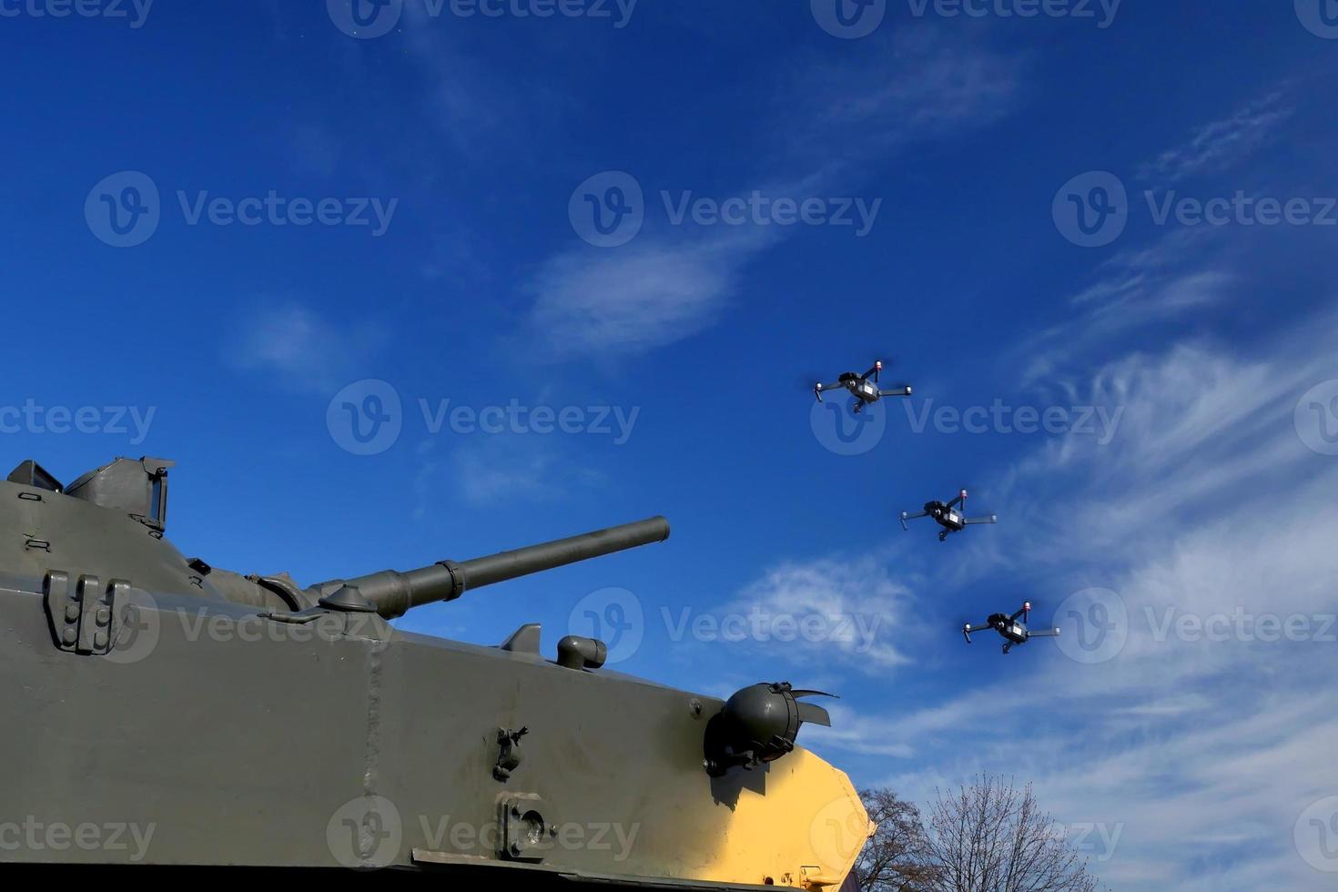 Der Panzer zielt mit einer Waffe auf die Drohne. Bekämpfung von Drohnen und Quadrocoptern foto