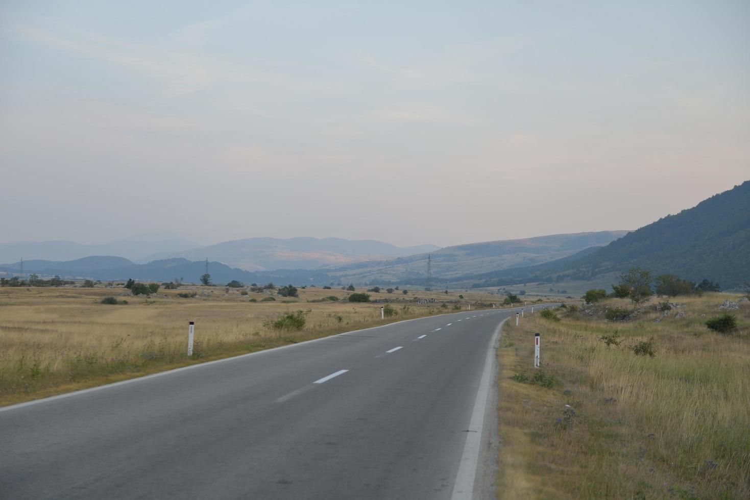 Straße durch die grüne Wiese foto