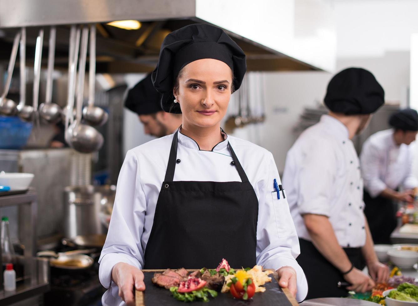 Köchin hält Rindersteakplatte foto