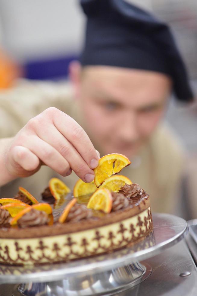 Koch bereitet Wüstenkuchen in der Küche zu foto