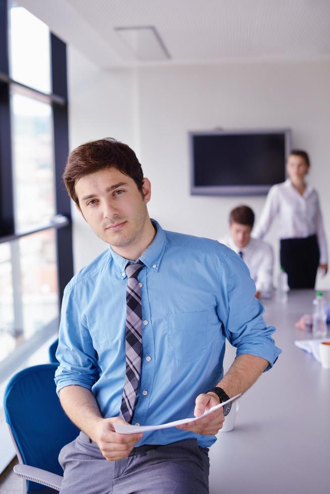 Geschäftsmann bei einem Treffen im Büro mit Kollegen im Hintergrund foto