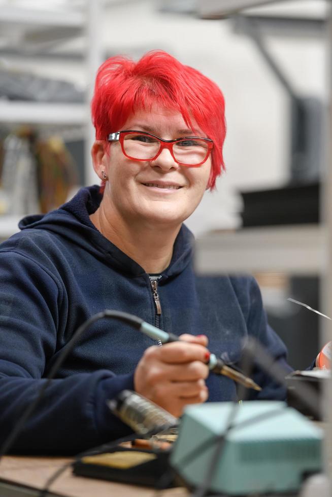 industriearbeiterin lötet kabel von fertigungsanlagen in einer fabrik foto