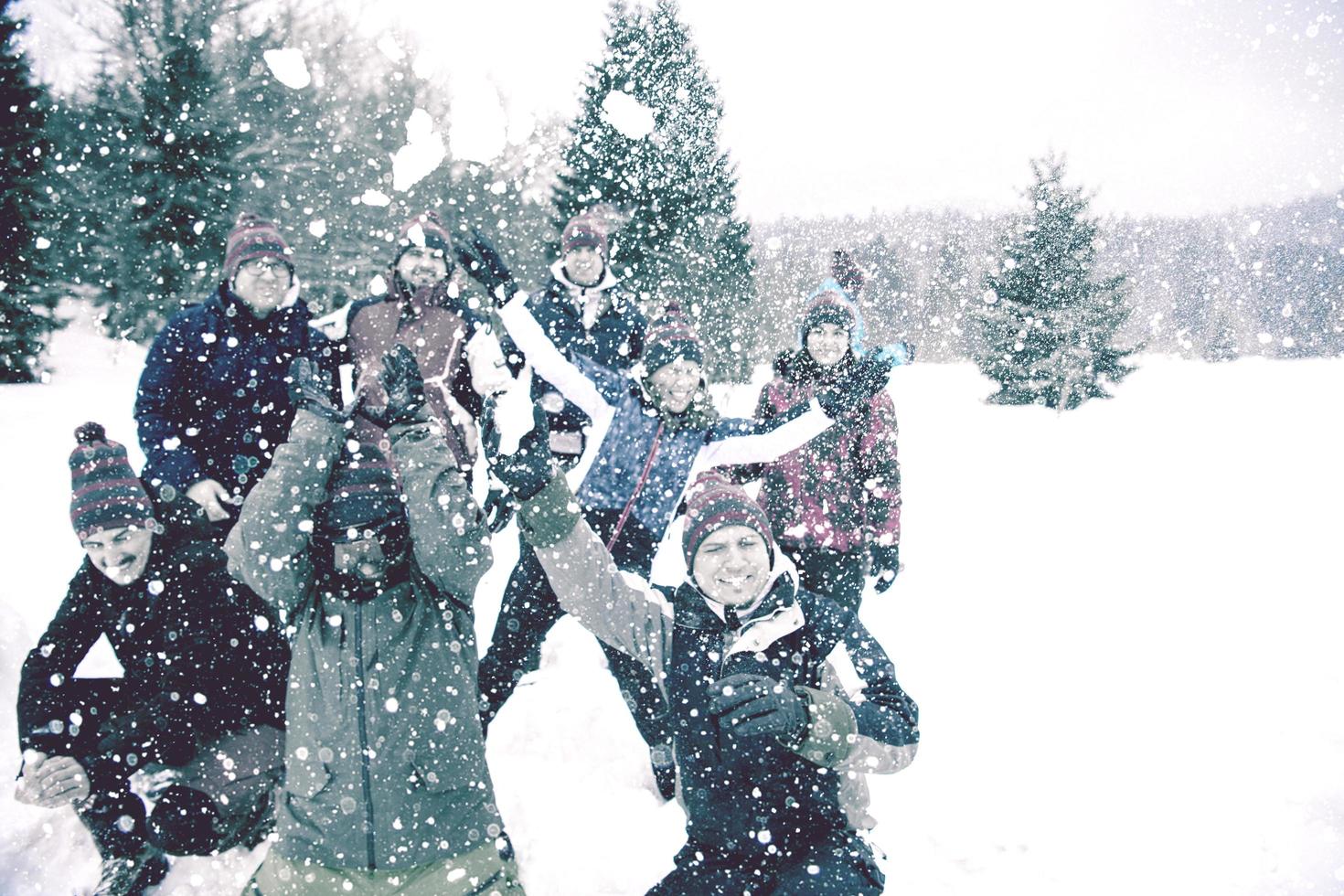 Gruppe junger Leute, die Schnee in die Luft werfen foto