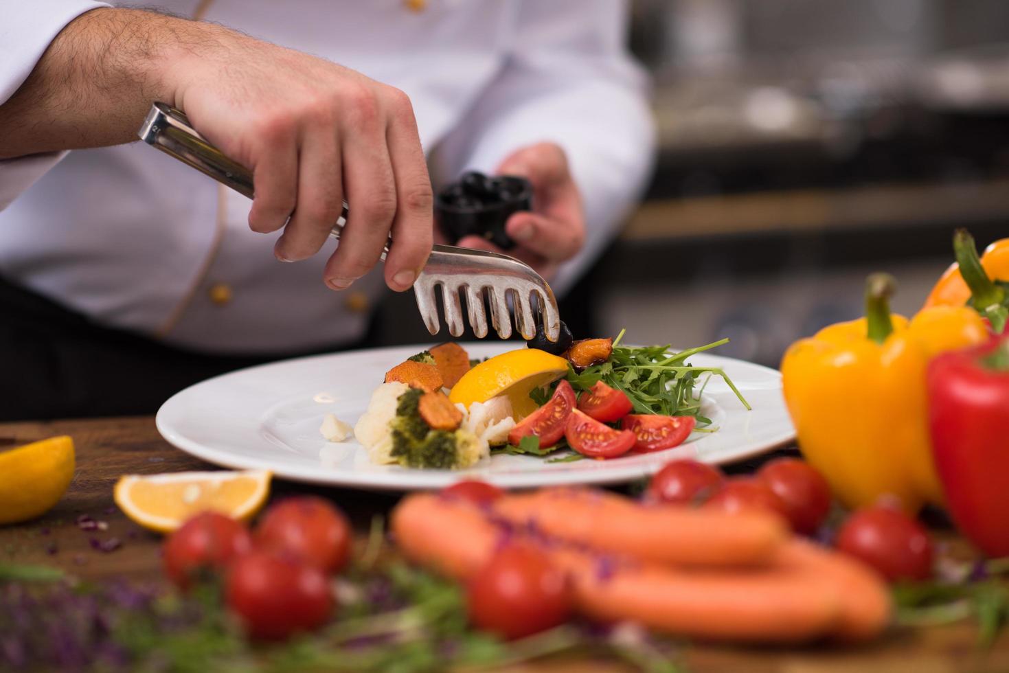 Koch serviert Gemüsesalat foto