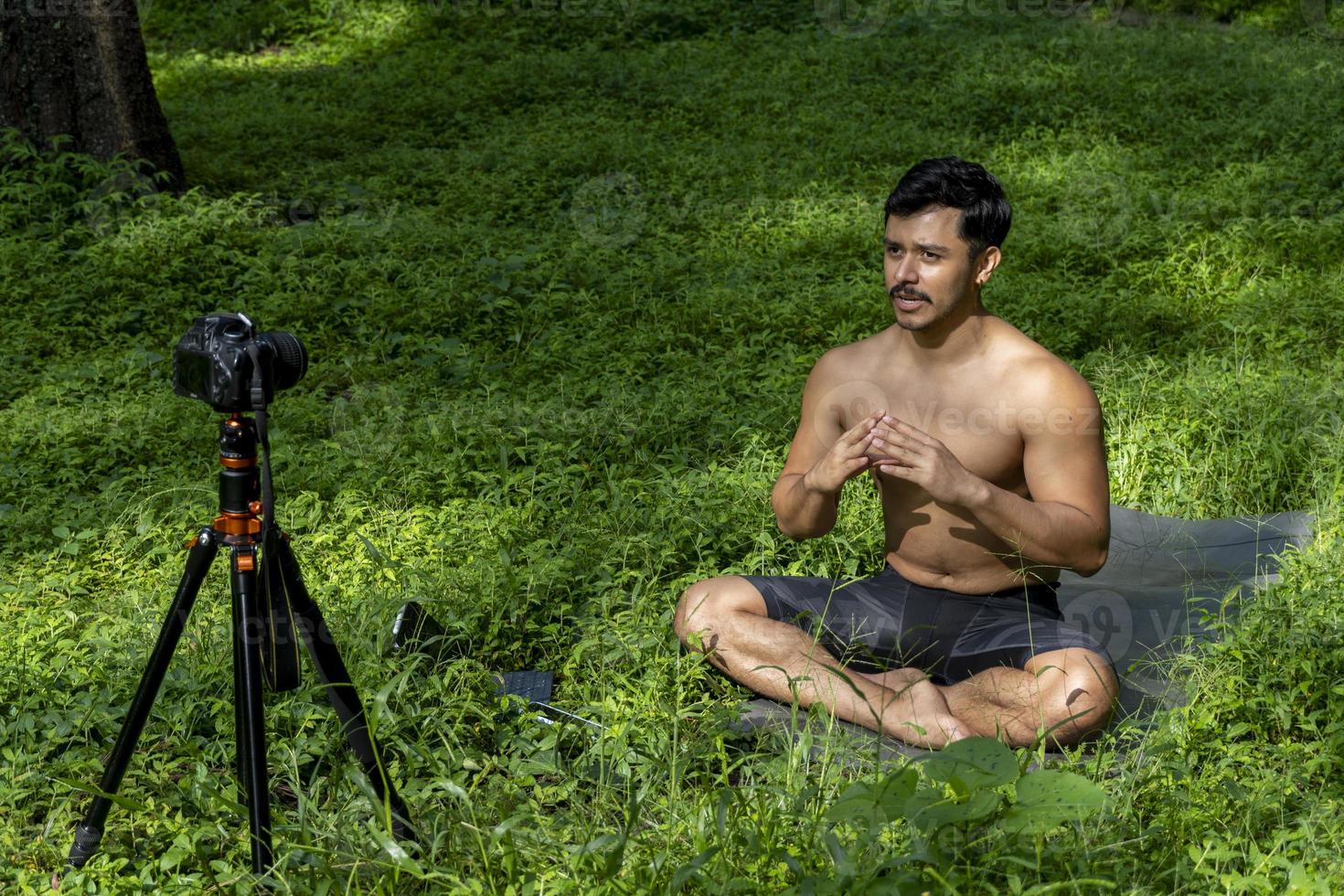 Blick auf einen Mann, der einen virtuellen Fitnesskurs mit einer Gruppe von Menschen zu Hause bei einer Videokonferenz durchführt. Fitnesstrainer, der Online-Yoga-Kurse nimmt foto