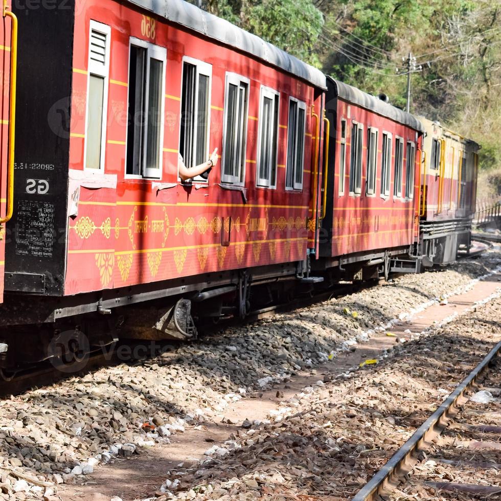 Spielzeugeisenbahn, die sich auf Berghängen bewegt, schöne Aussicht, ein Seitenberg, ein Seitental, das sich auf der Eisenbahn zum Hügel bewegt, inmitten grüner Naturwälder. spielzeugeisenbahn von kalka nach shimla in indien, indischer zug foto