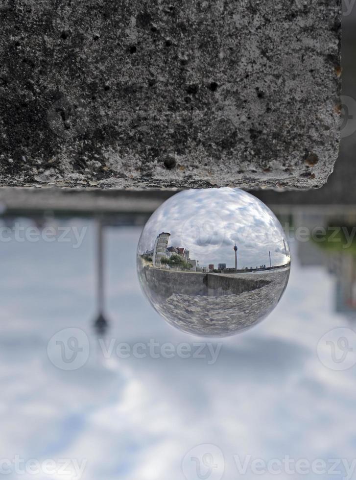 umgekehrte ansicht von düsseldorf in einer kristallkugel auf einer steinmauer foto