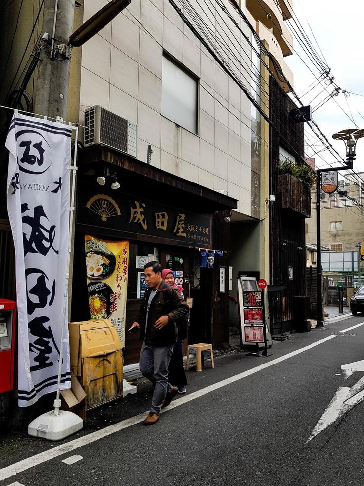 osaka, japan am 10. april 2019. ein muslimischer junger mann und eine muslimische frau betreten einen halal-ramen-laden in osaka. foto