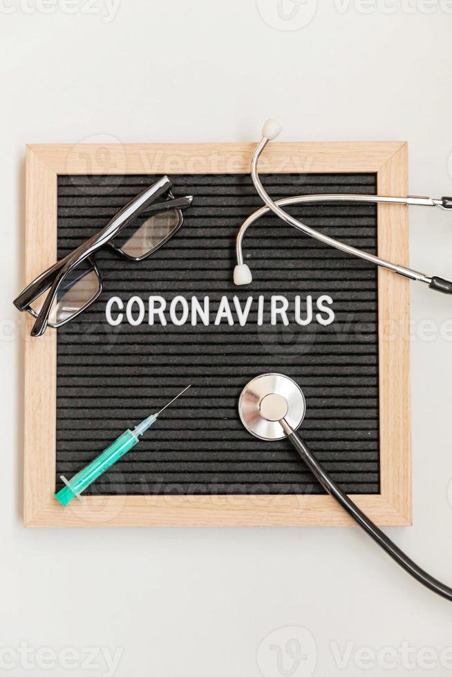 textphrase coronavirus spritze und stethoskop auf schwarzem buchstabenbretthintergrund. neuartiges Coronavirus 2019-ncov, Mers-cov-Coronavirus des Atemwegssyndroms im Nahen Osten mit Ursprung in Wuhan, China foto